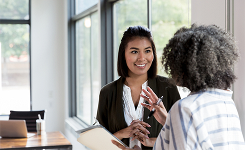 two female employees having a conversation at work